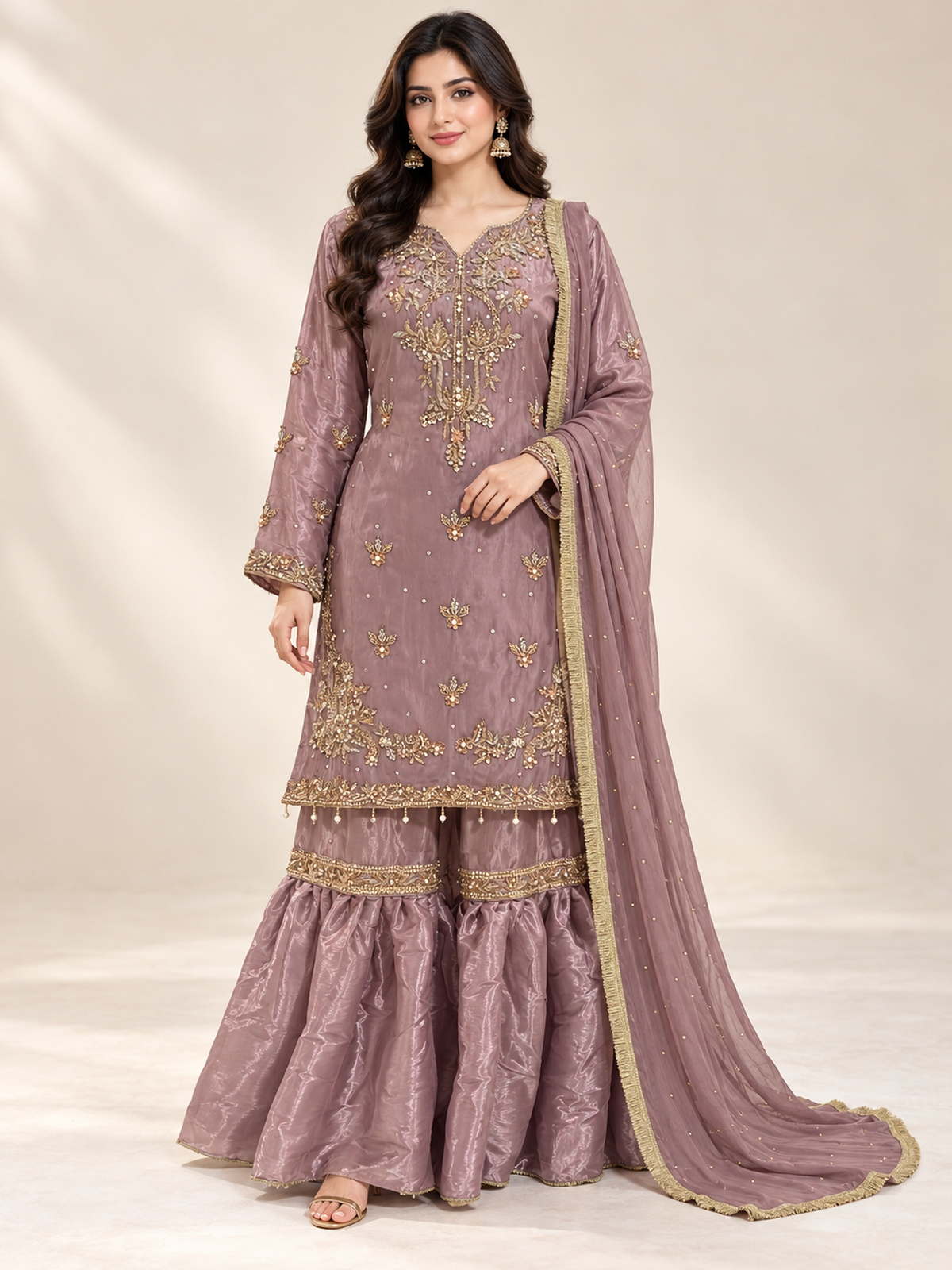 A dusty mauve ensemble with floral neckline embroidery, tiered gharara-style trousers and a matching dupatta.
