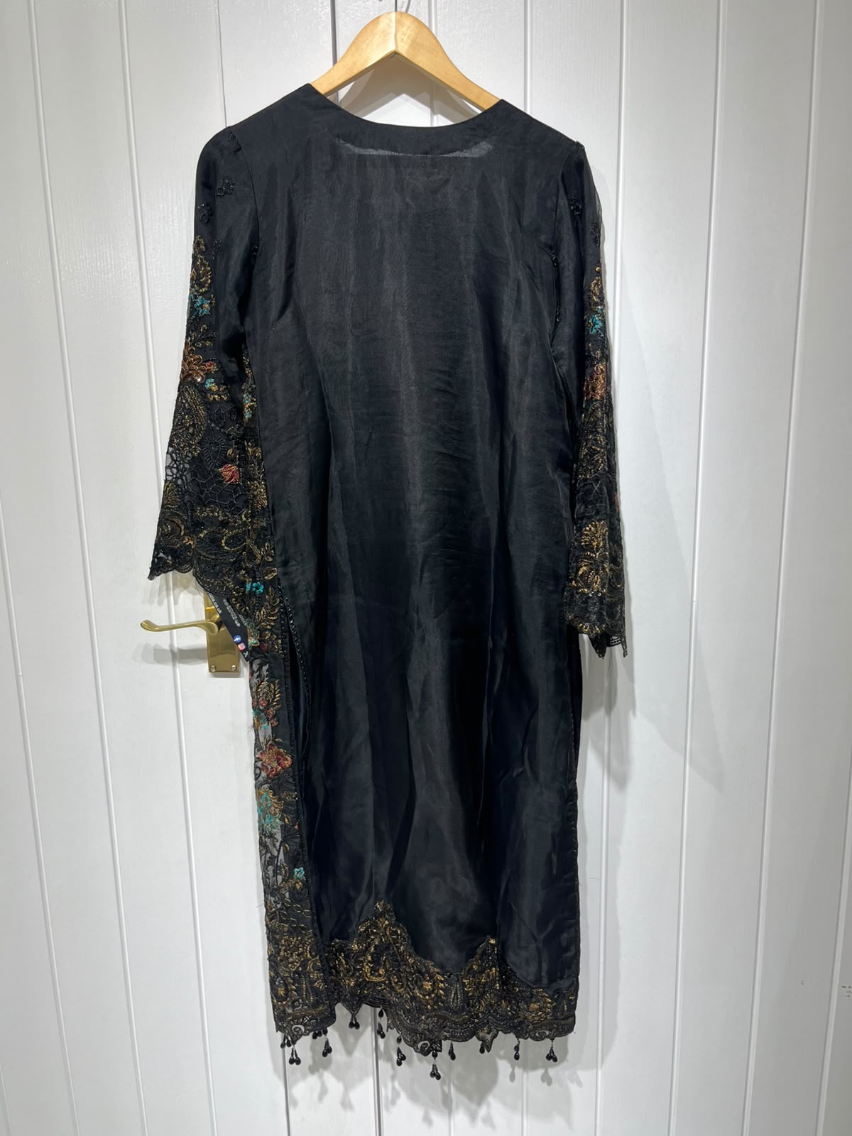 A black ensemble with multicolour floral embroidery, ornate…