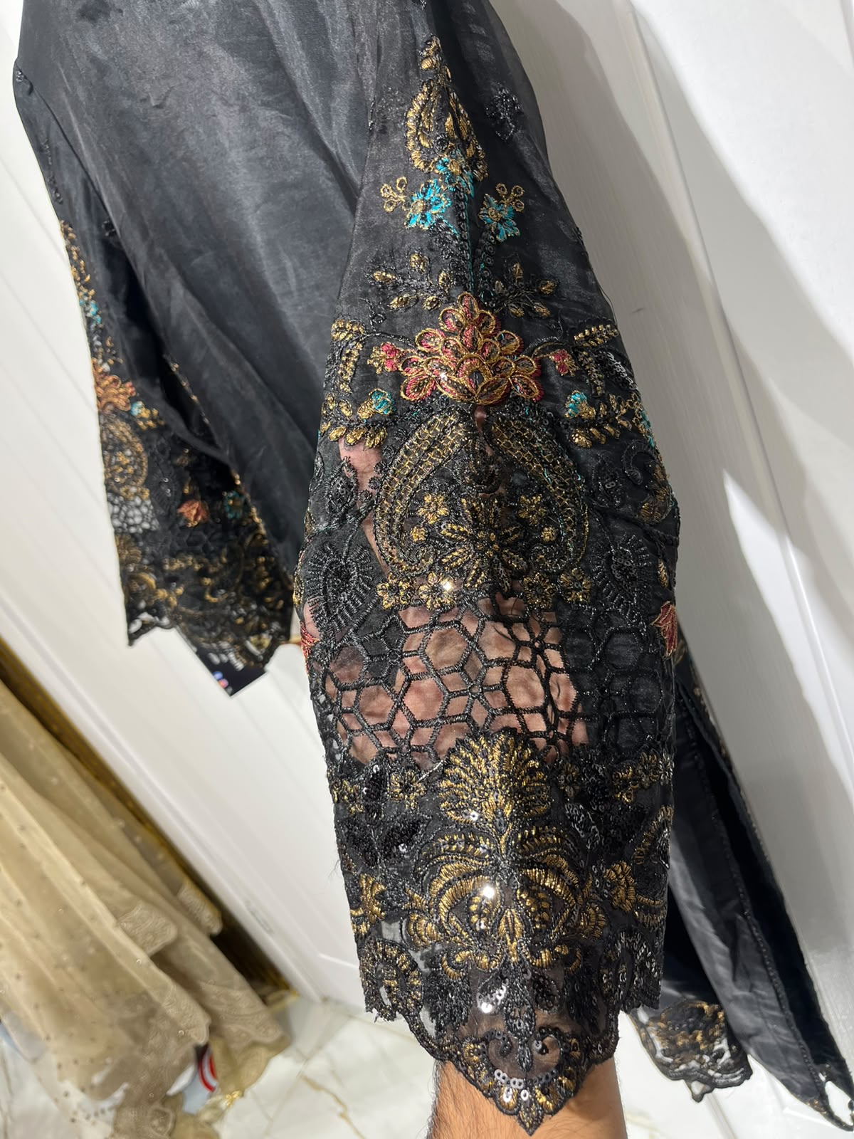 A black ensemble with multicolour floral embroidery, ornate…