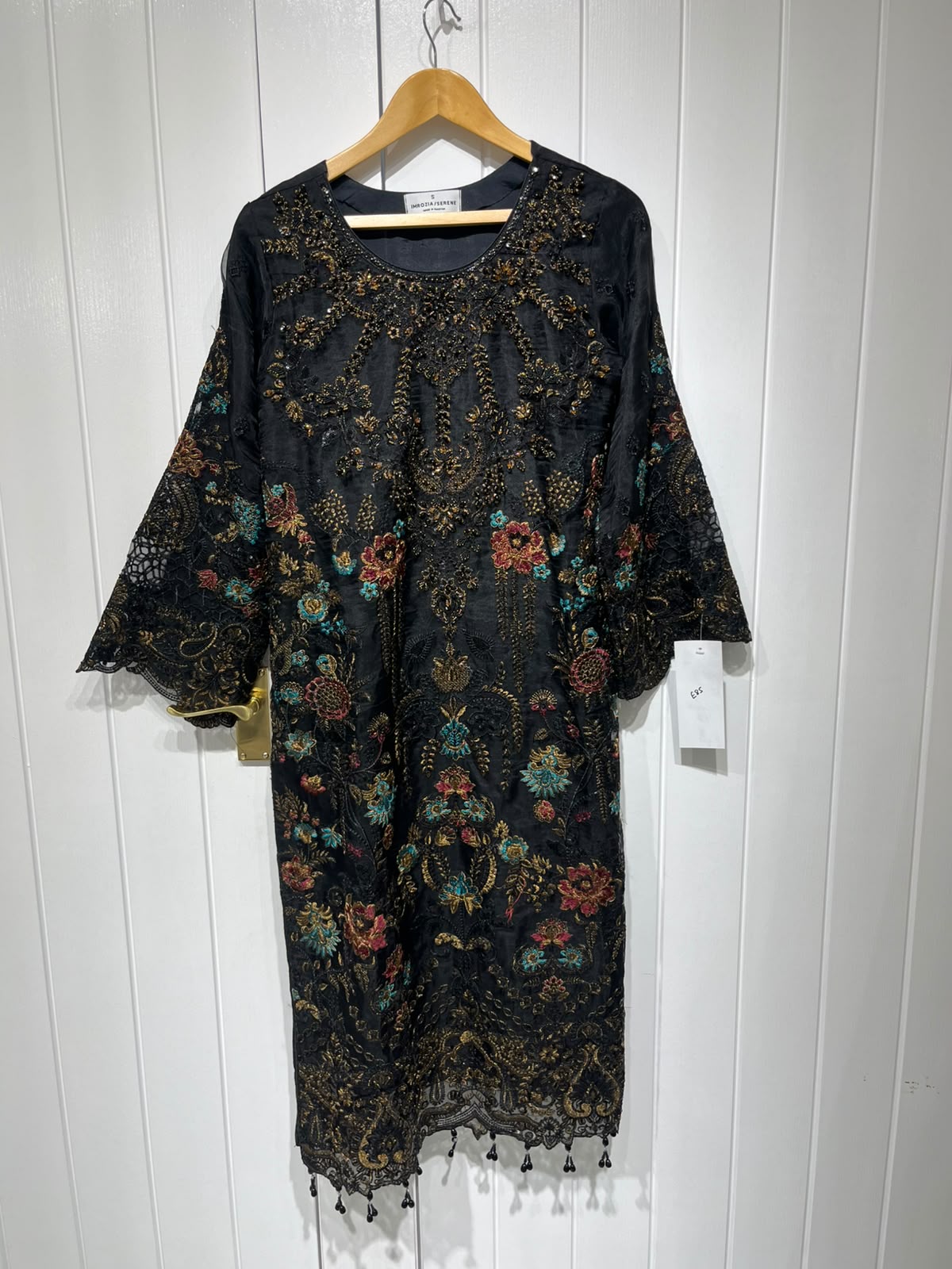 A black ensemble with multicolour floral embroidery, ornate…