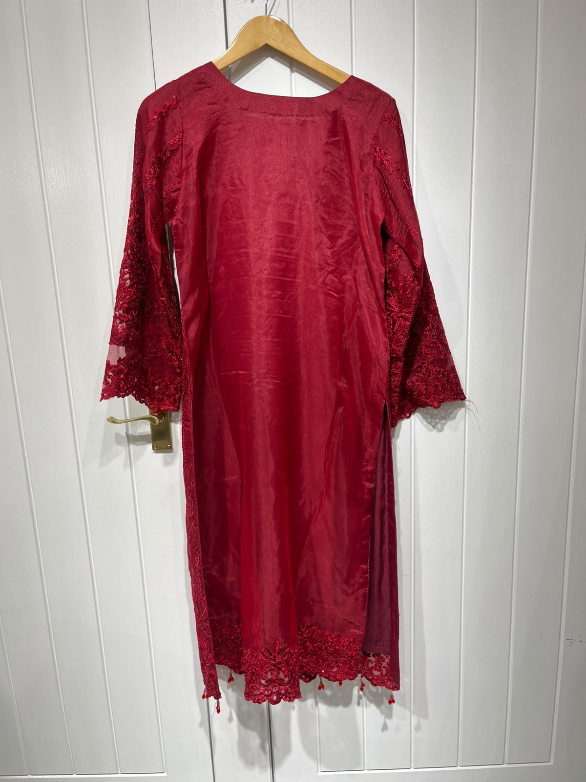 A deep red ensemble with tonal floral embroidery, sheer sleeve…