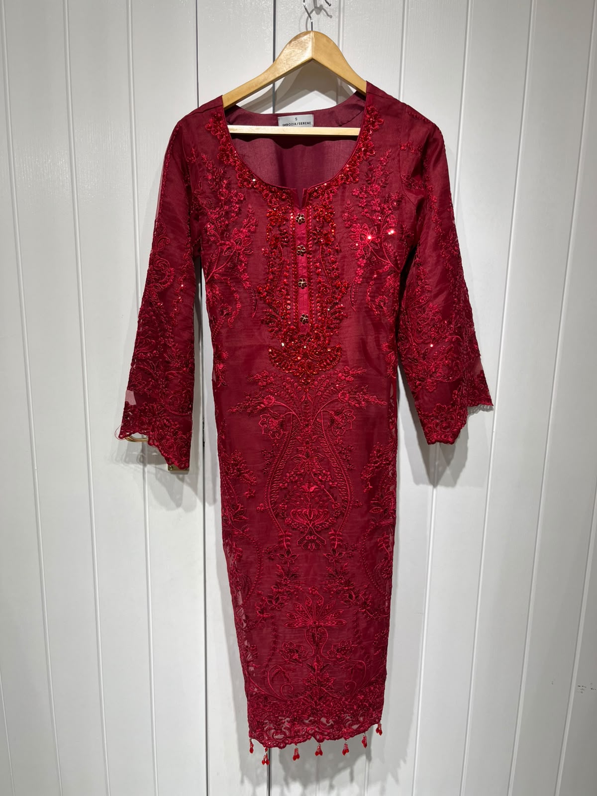 A deep red ensemble with tonal floral embroidery, sheer sleeve…