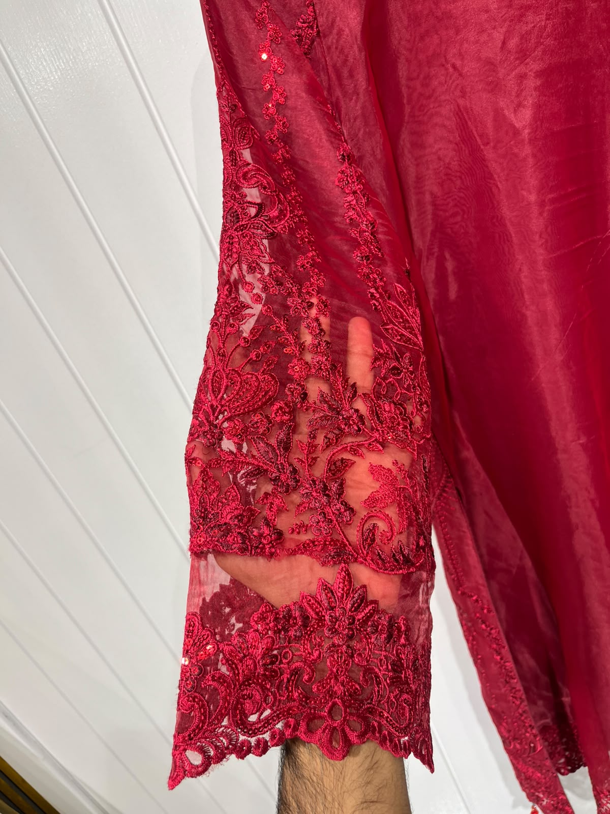 A deep red ensemble with tonal floral embroidery, sheer sleeve…