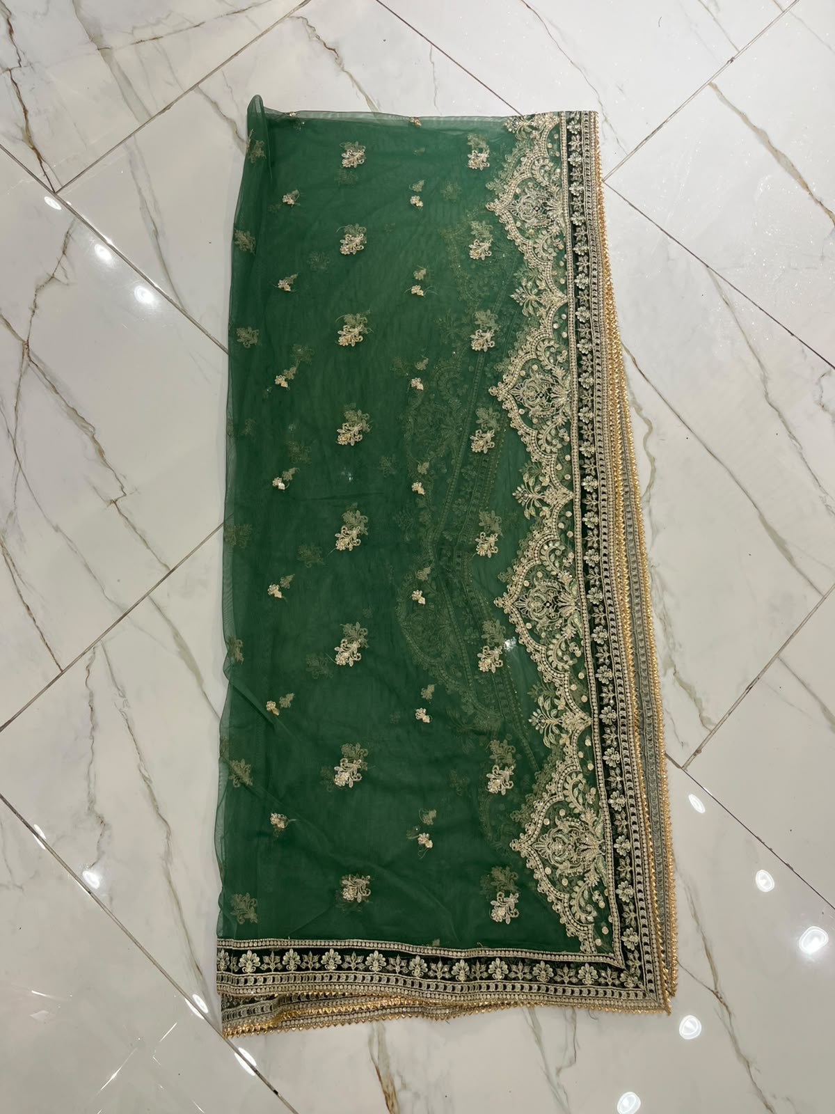 A green ensemble with ornate gold-toned embroidery, statement cuffs…