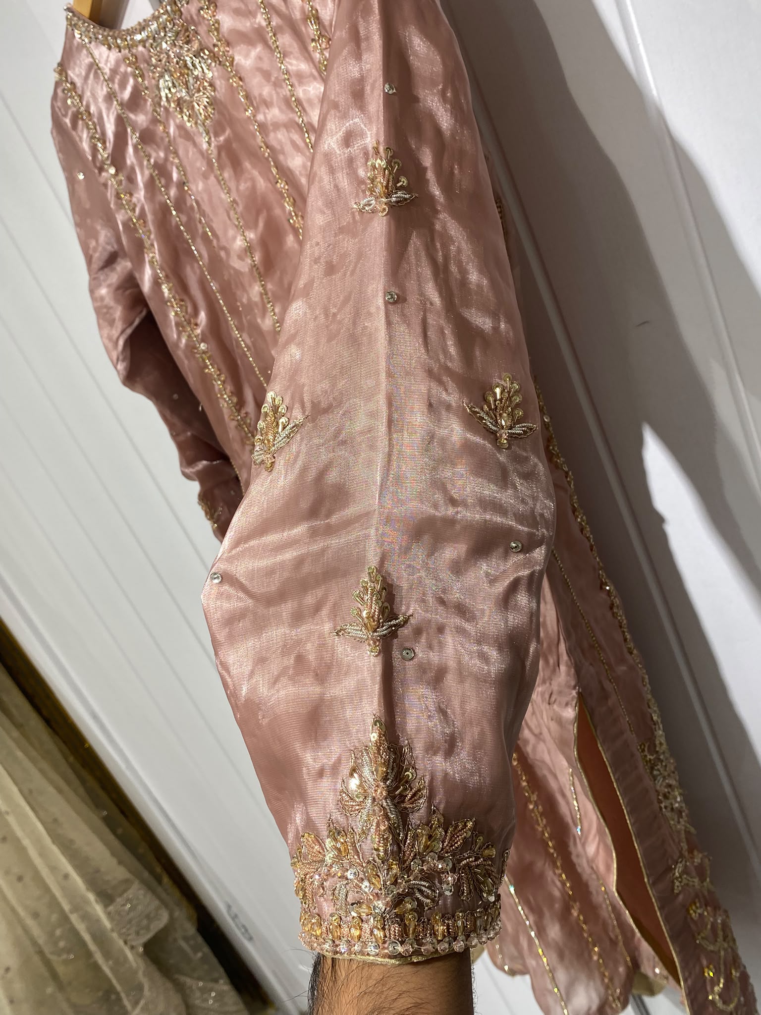 A dusty rose ensemble with a richly embroidered front, decorated…