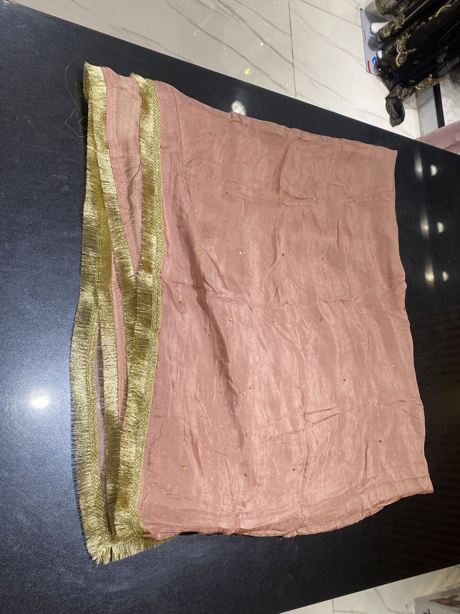 A dusty rose ensemble with a richly embroidered front, decorated…