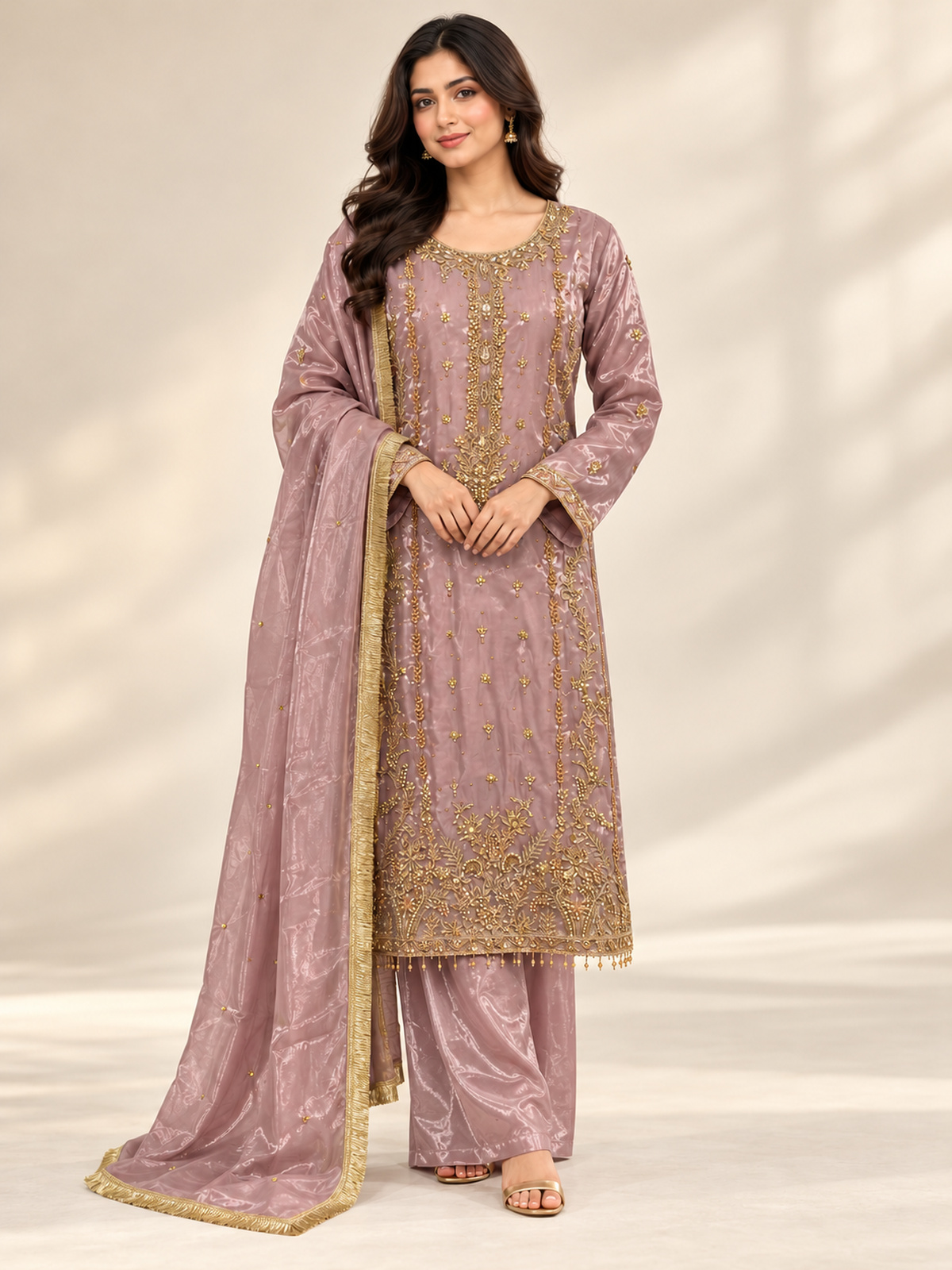 A dusty mauve ensemble with a long gold-toned neckline, vertical…