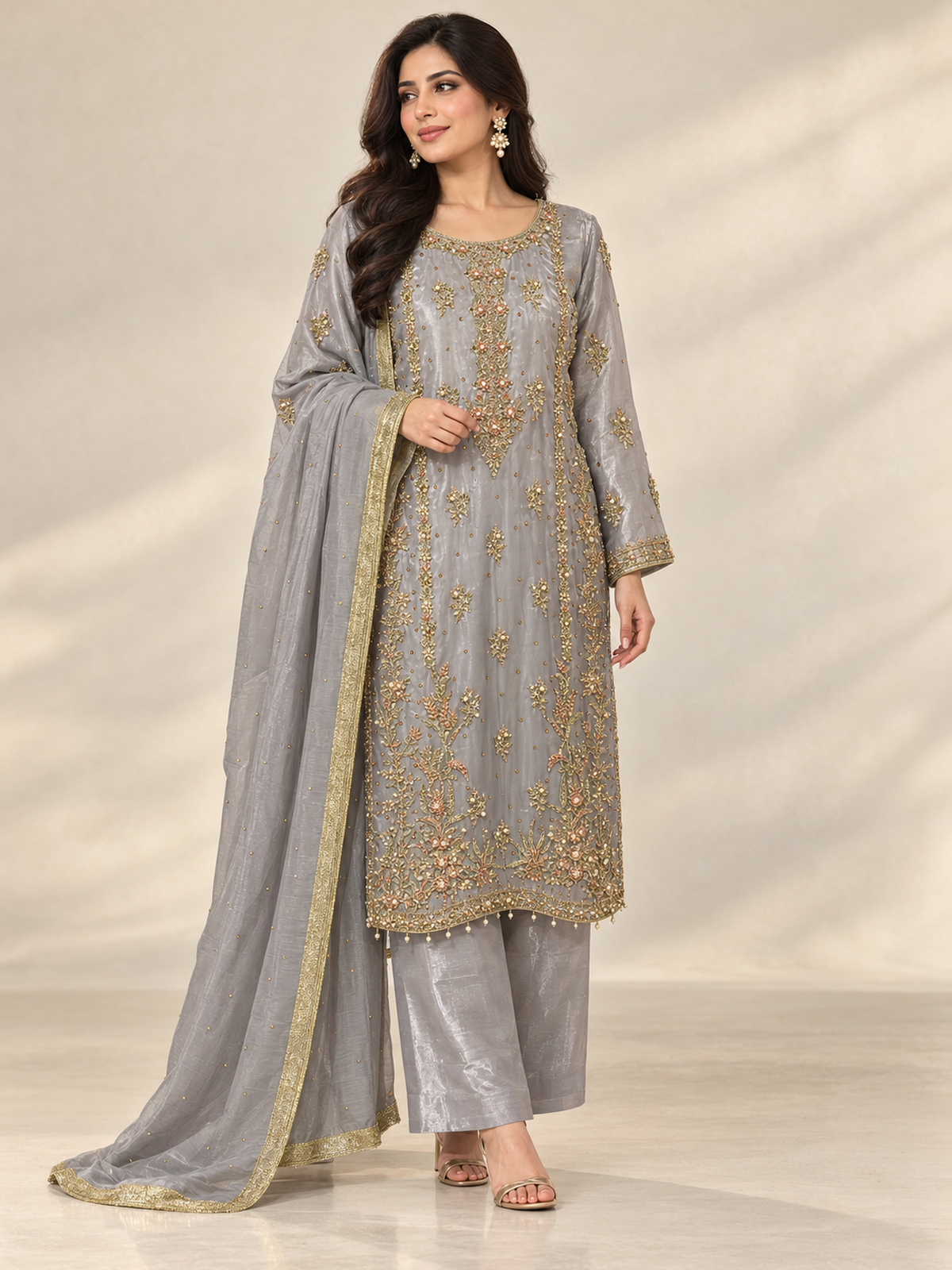A silver grey ensemble with ornate gold-toned embroidery, decorated…