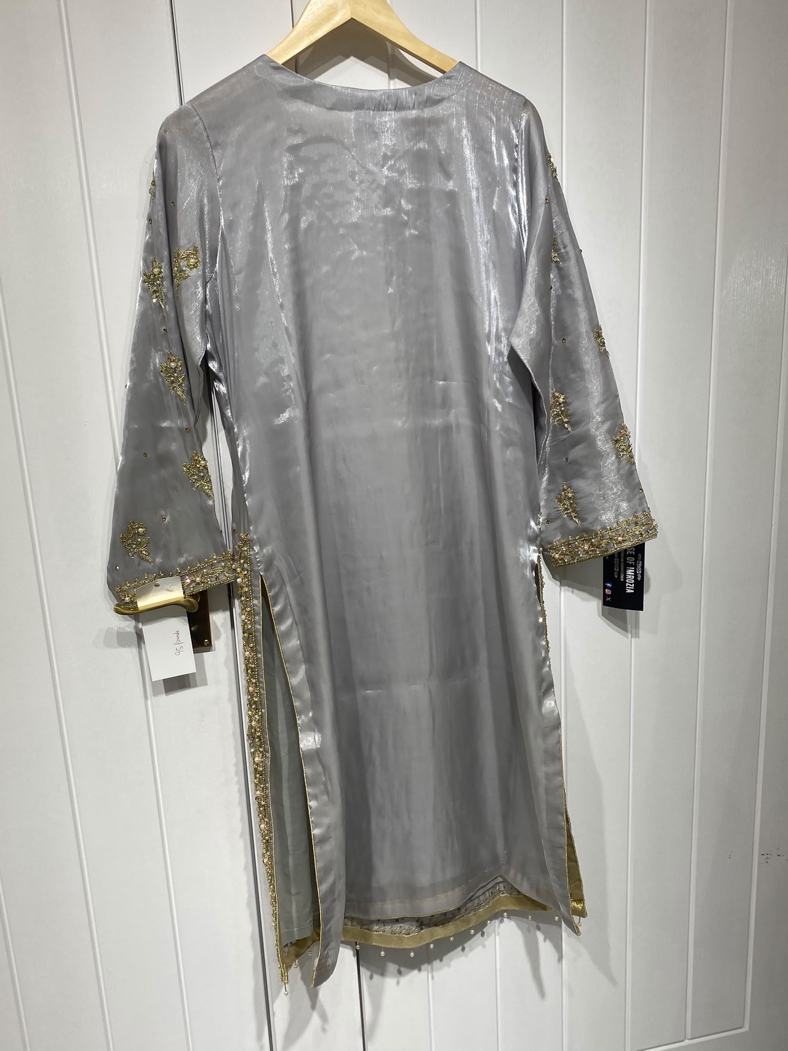 A silver grey ensemble with ornate gold-toned embroidery, decorated…