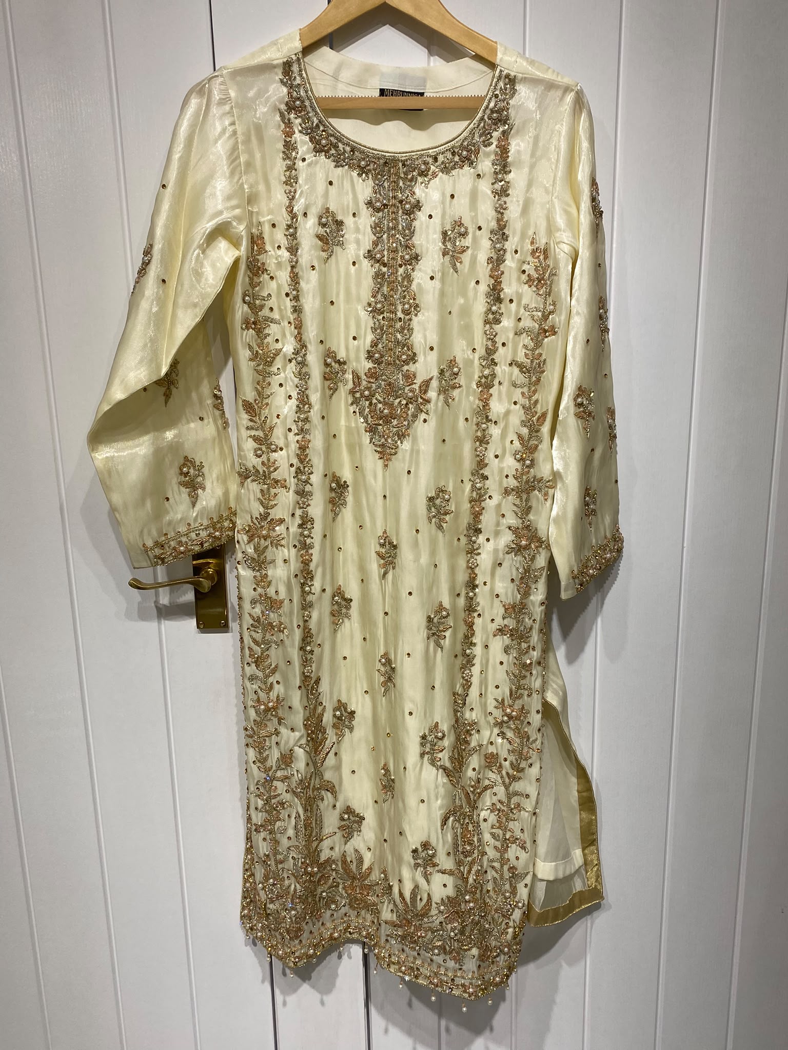 A pale yellow ensemble with dense gold-toned floral panels…