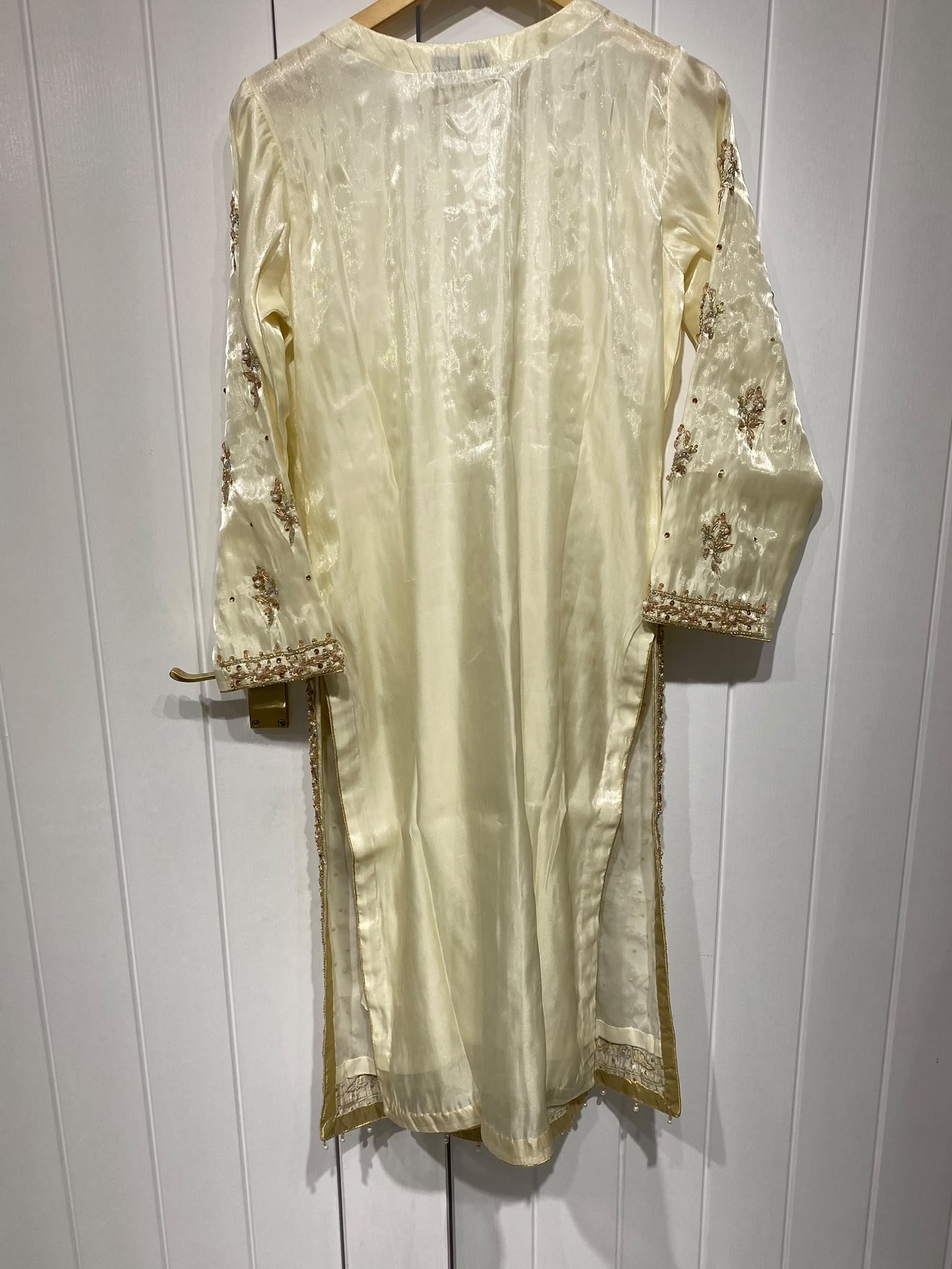 A pale yellow ensemble with dense gold-toned floral panels…