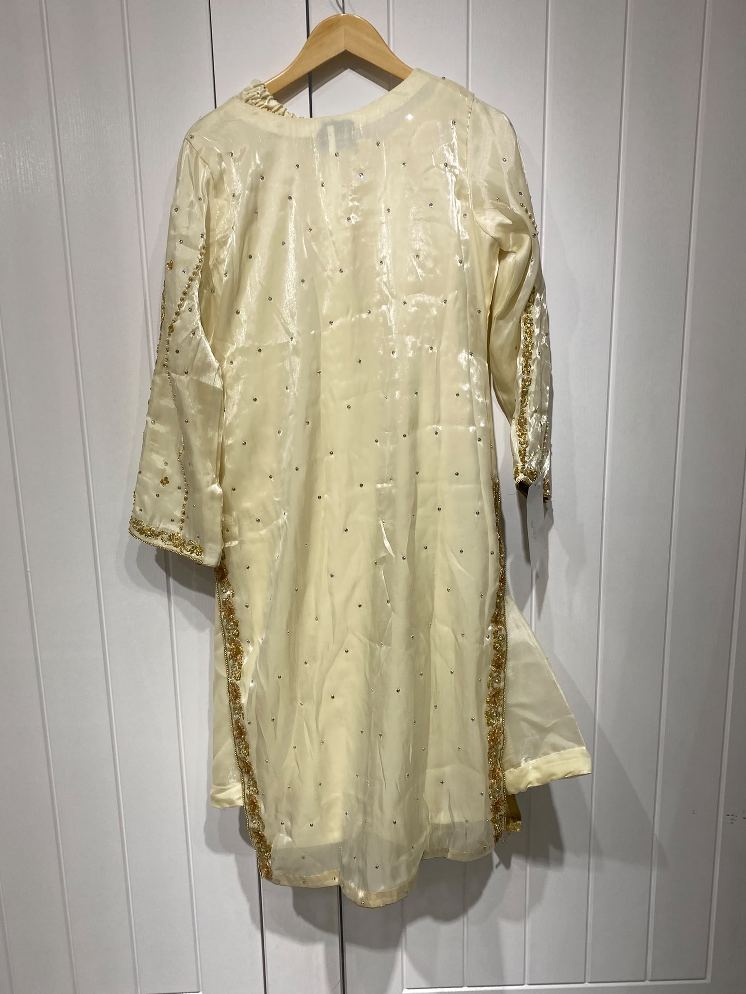 A pale yellow ensemble with a framed embroidered chest panel…