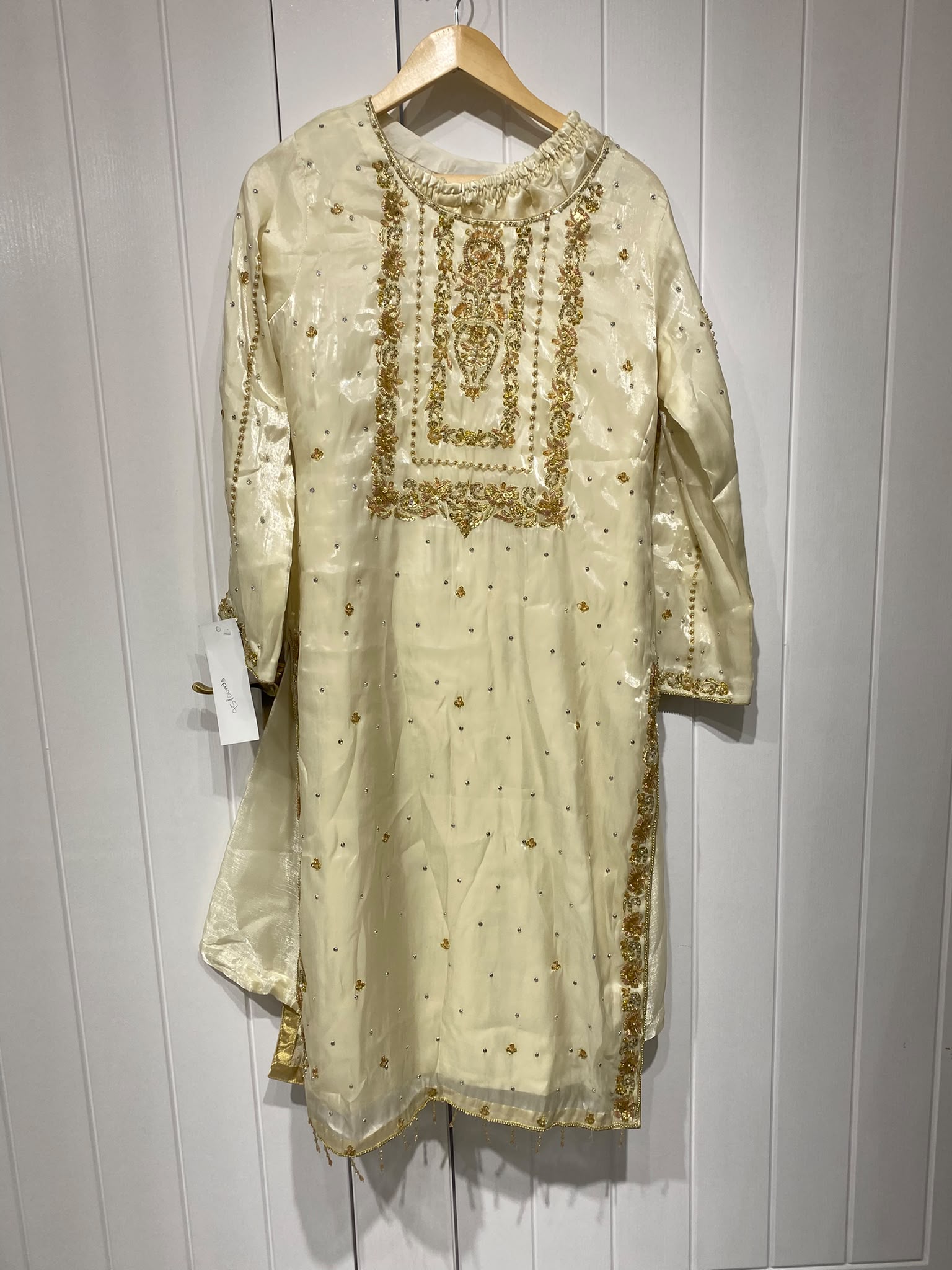 A pale yellow ensemble with a framed embroidered chest panel…