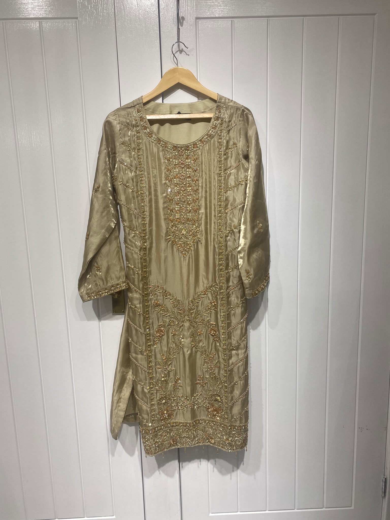 An olive gold ensemble with an elongated embroidered neckline, ornate…