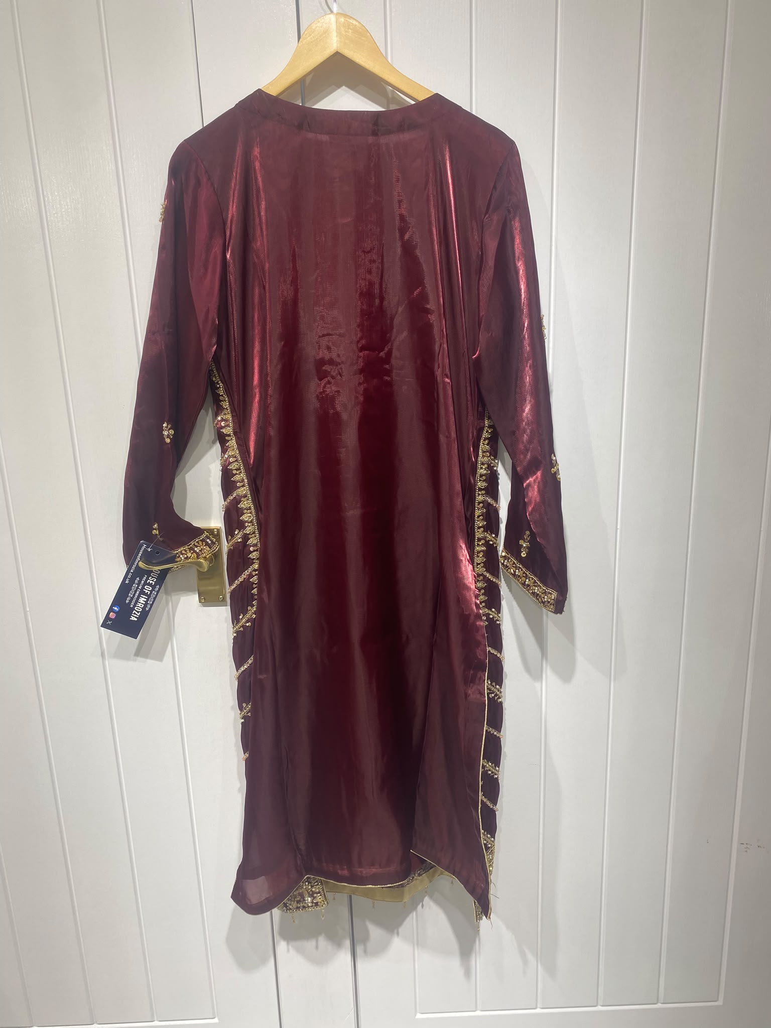 A deep burgundy ensemble with bold gold-toned geometric embroidery…