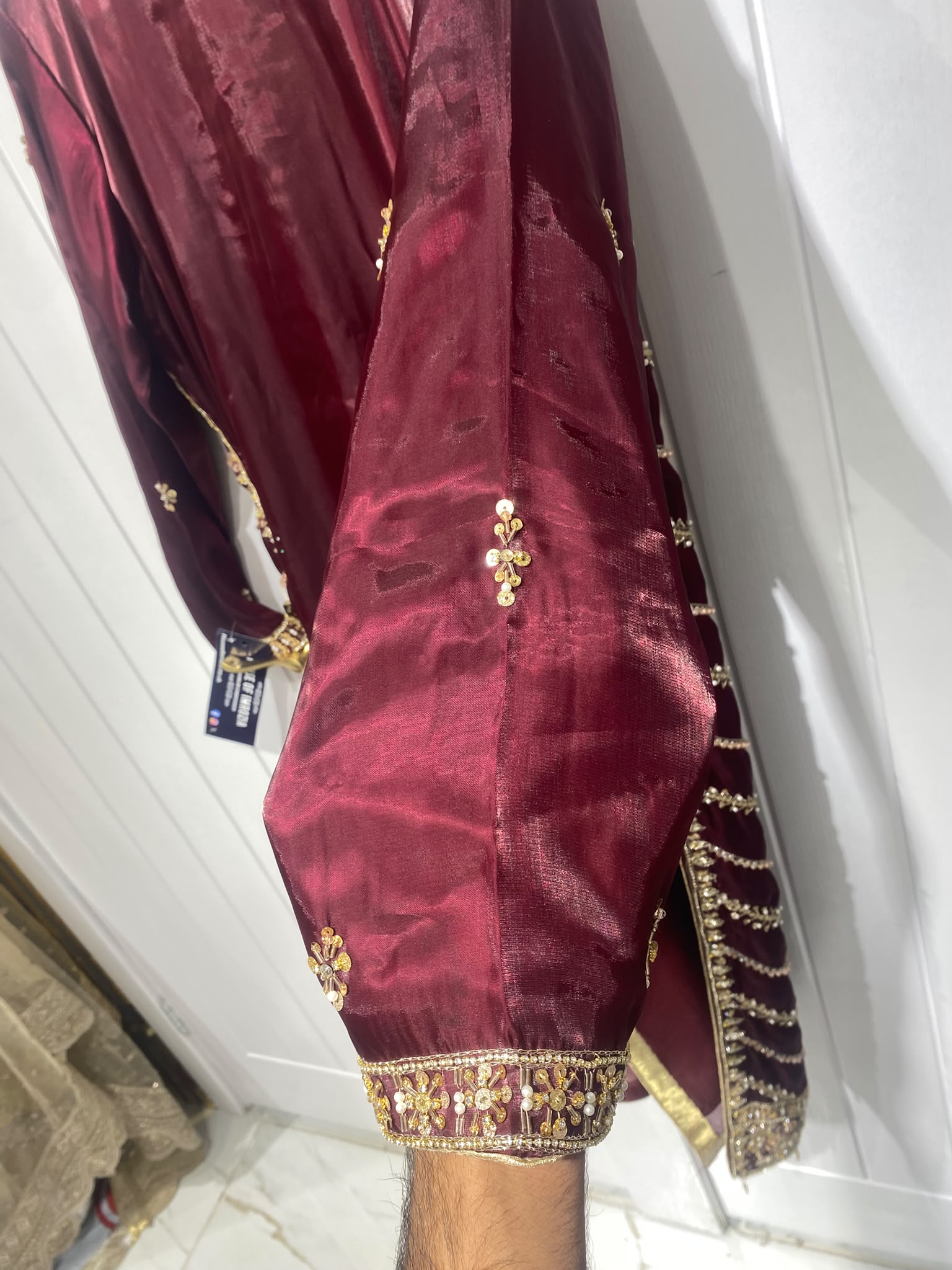 A deep burgundy ensemble with bold gold-toned geometric embroidery…