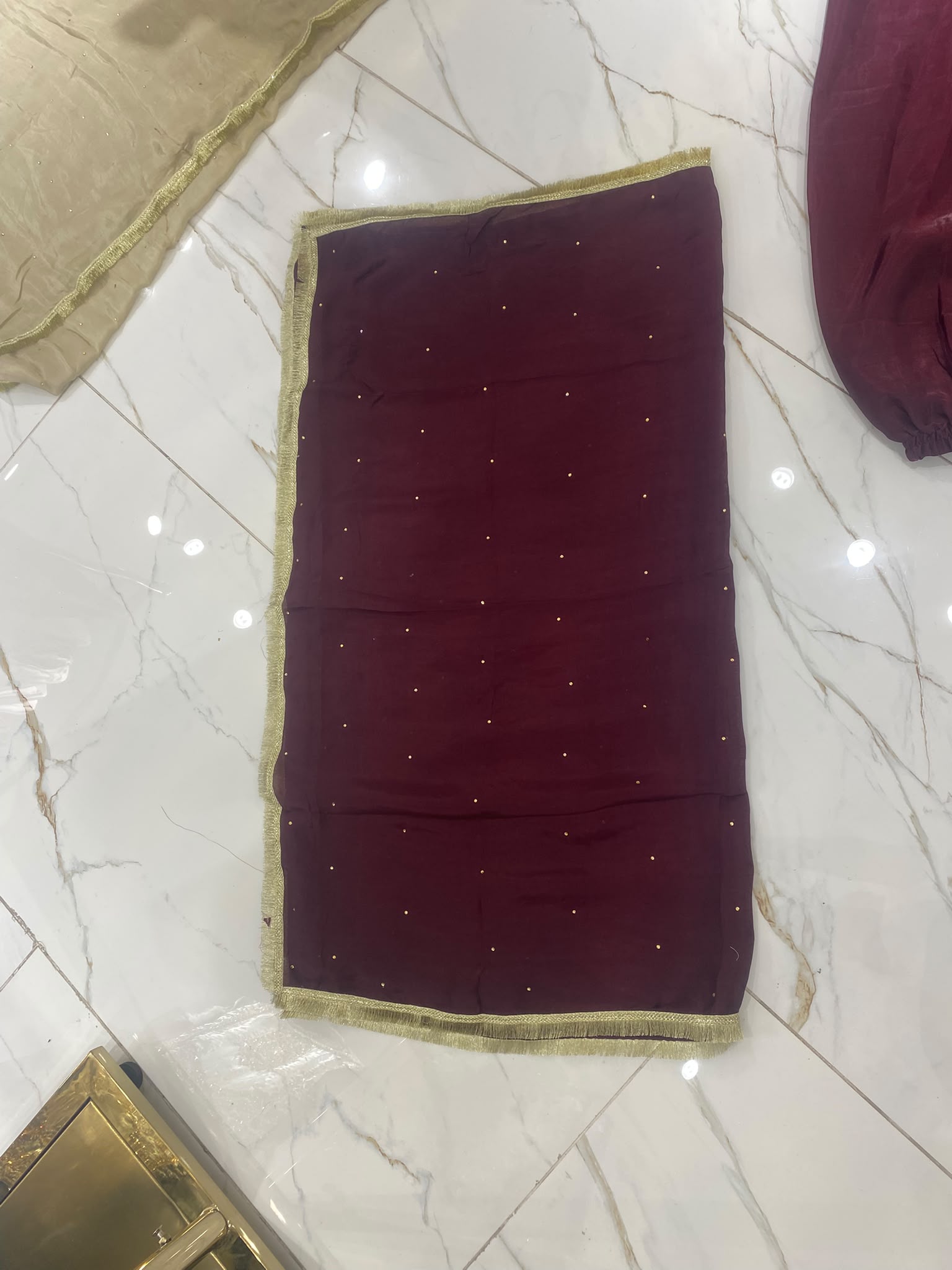 A deep burgundy ensemble with bold gold-toned geometric embroidery…