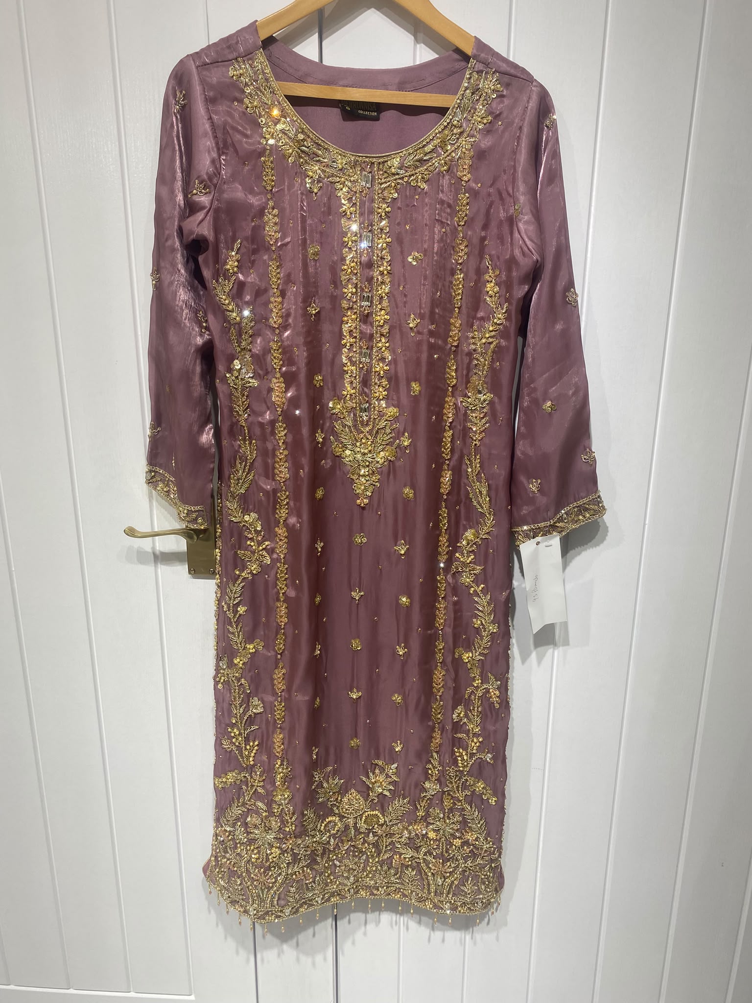 A mauve ensemble with elongated gold-toned neckline embroidery…