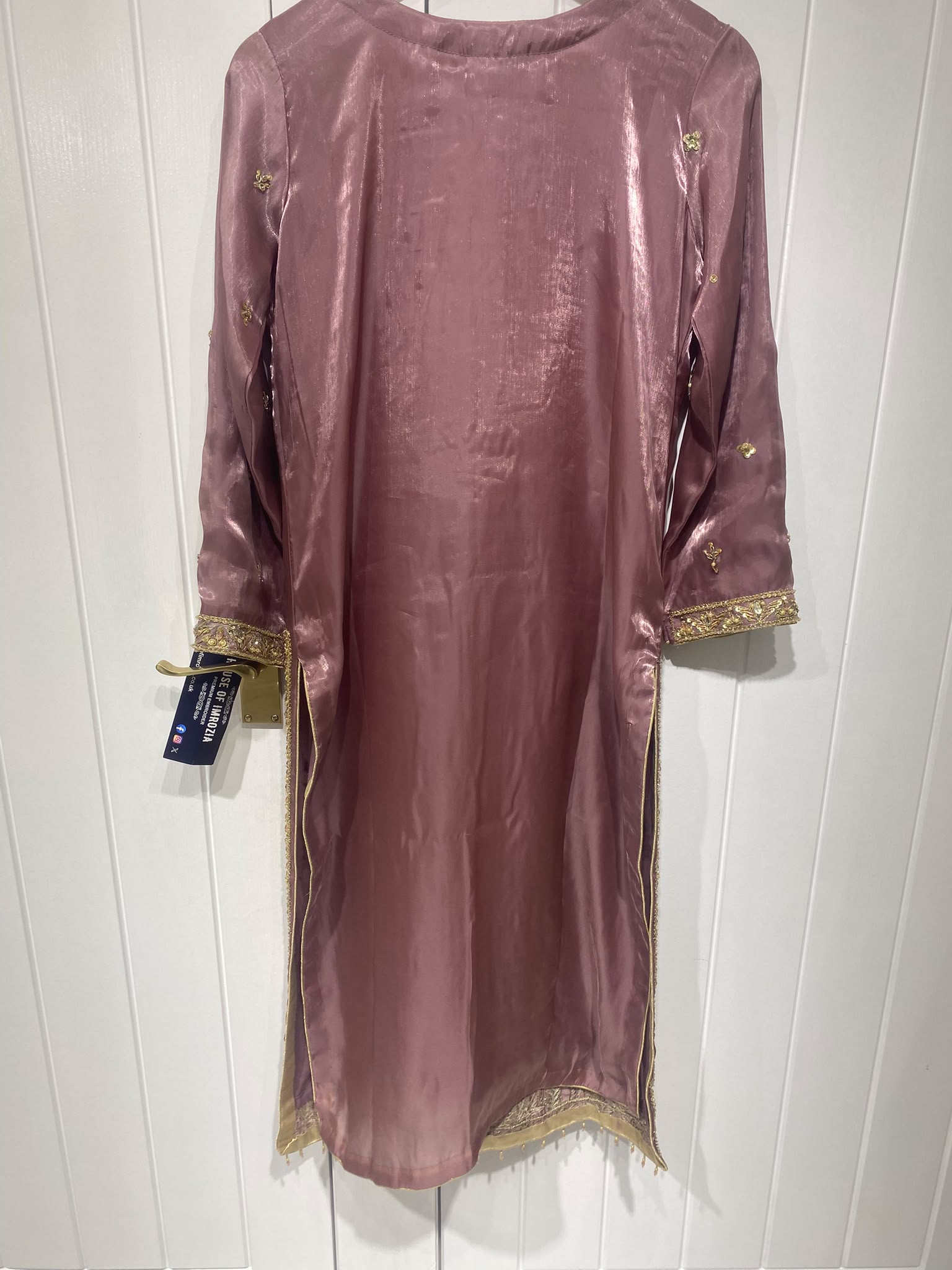 A mauve ensemble with elongated gold-toned neckline embroidery…