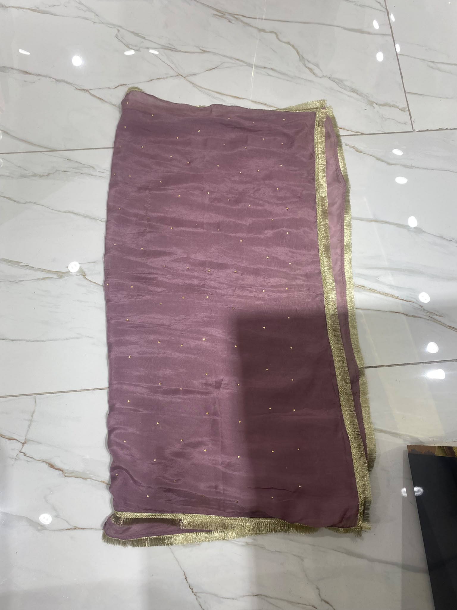A mauve ensemble with elongated gold-toned neckline embroidery…