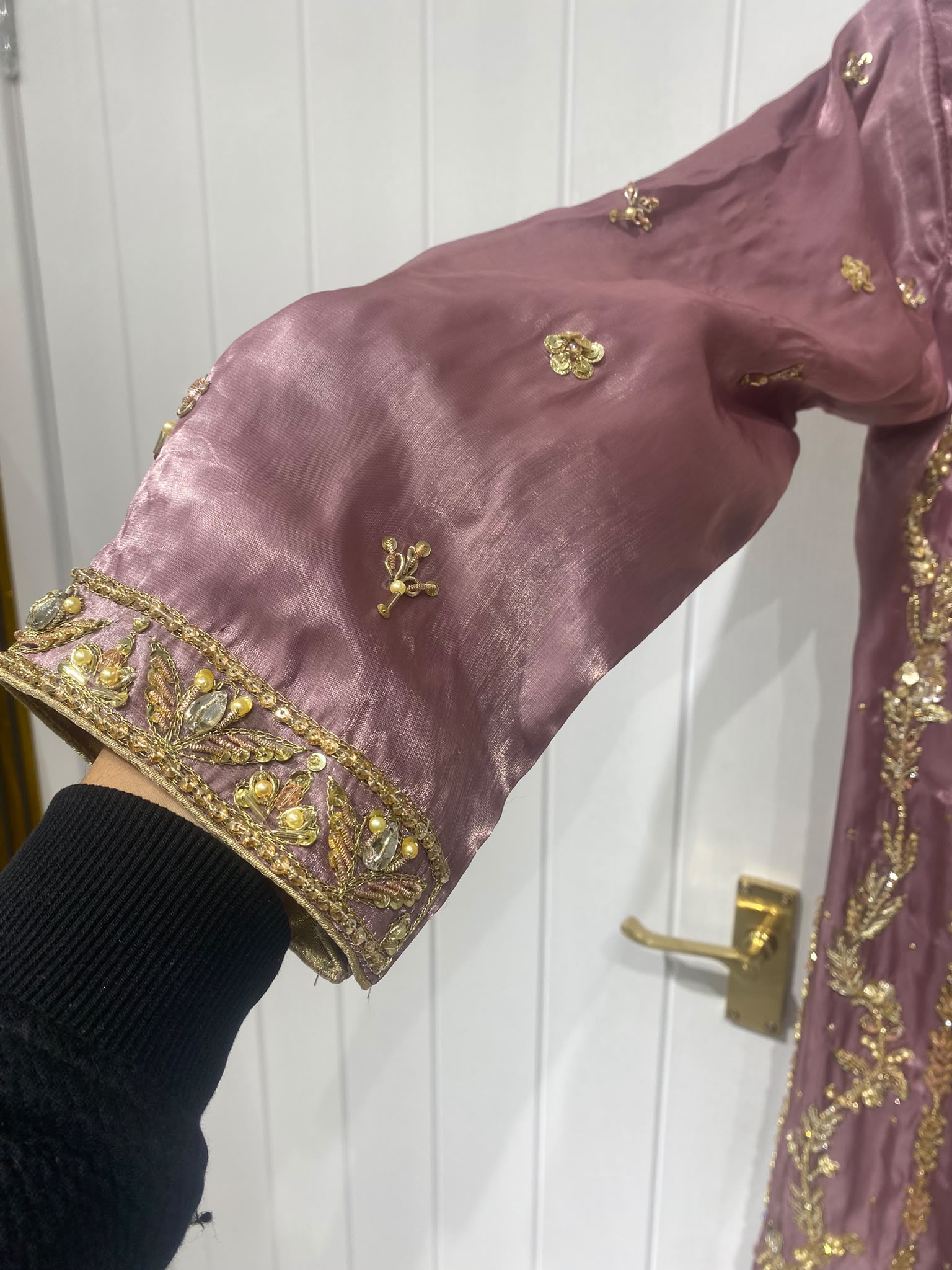 A mauve ensemble with elongated gold-toned neckline embroidery…