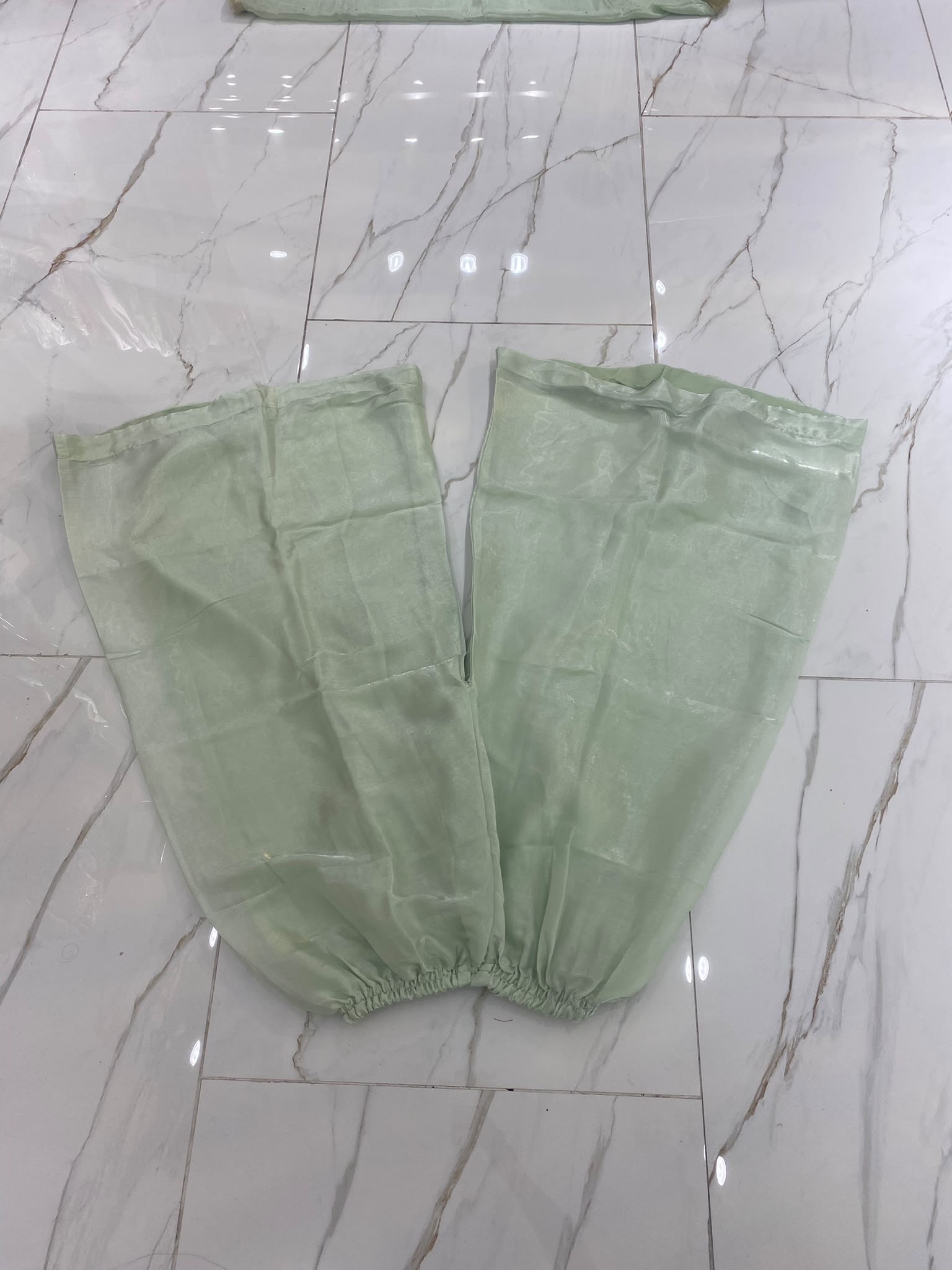 A pistachio green ensemble with a framed embroidered bib, scattered…