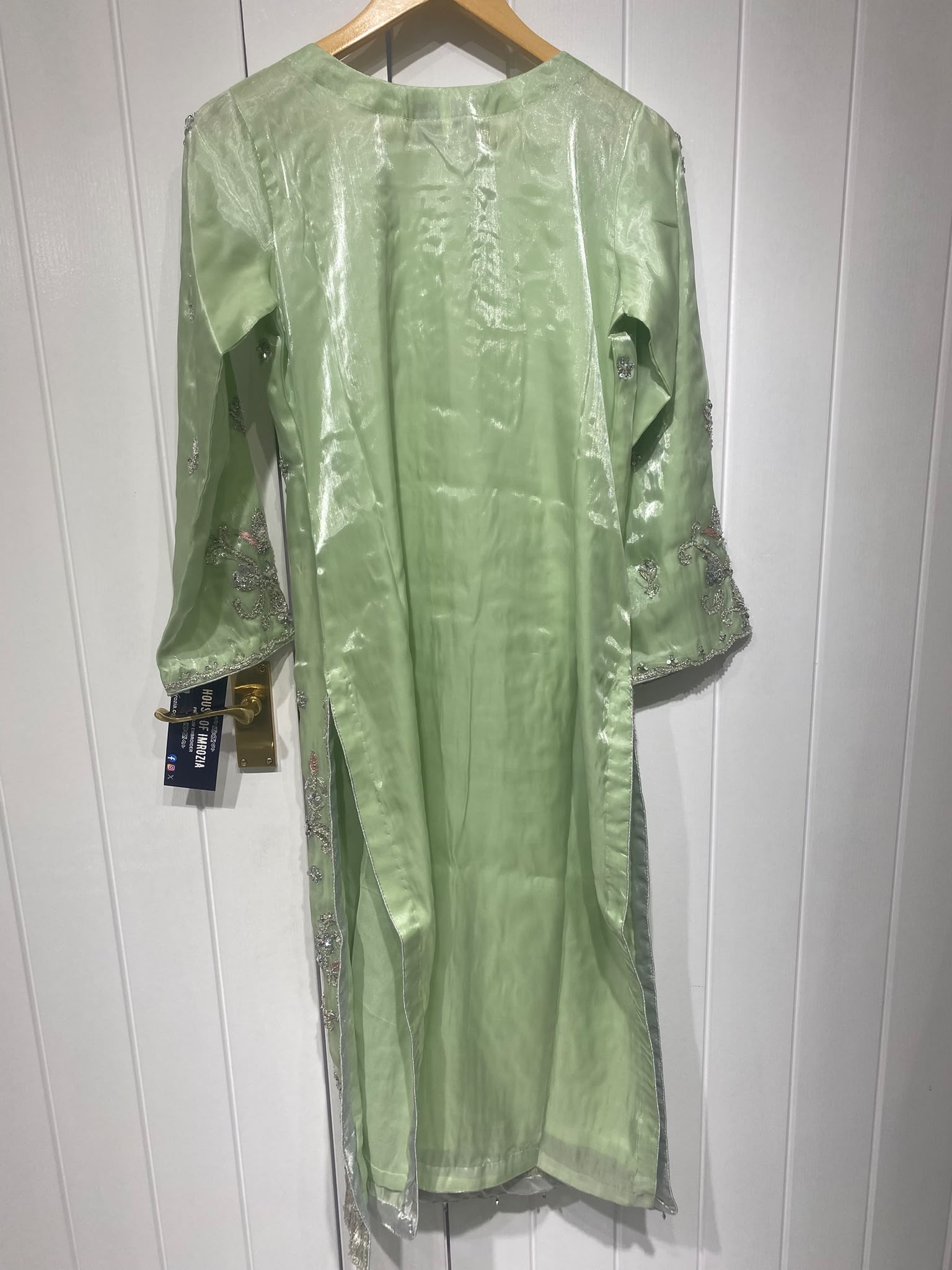 A light green ensemble with silver-toned floral embroidery, a…
