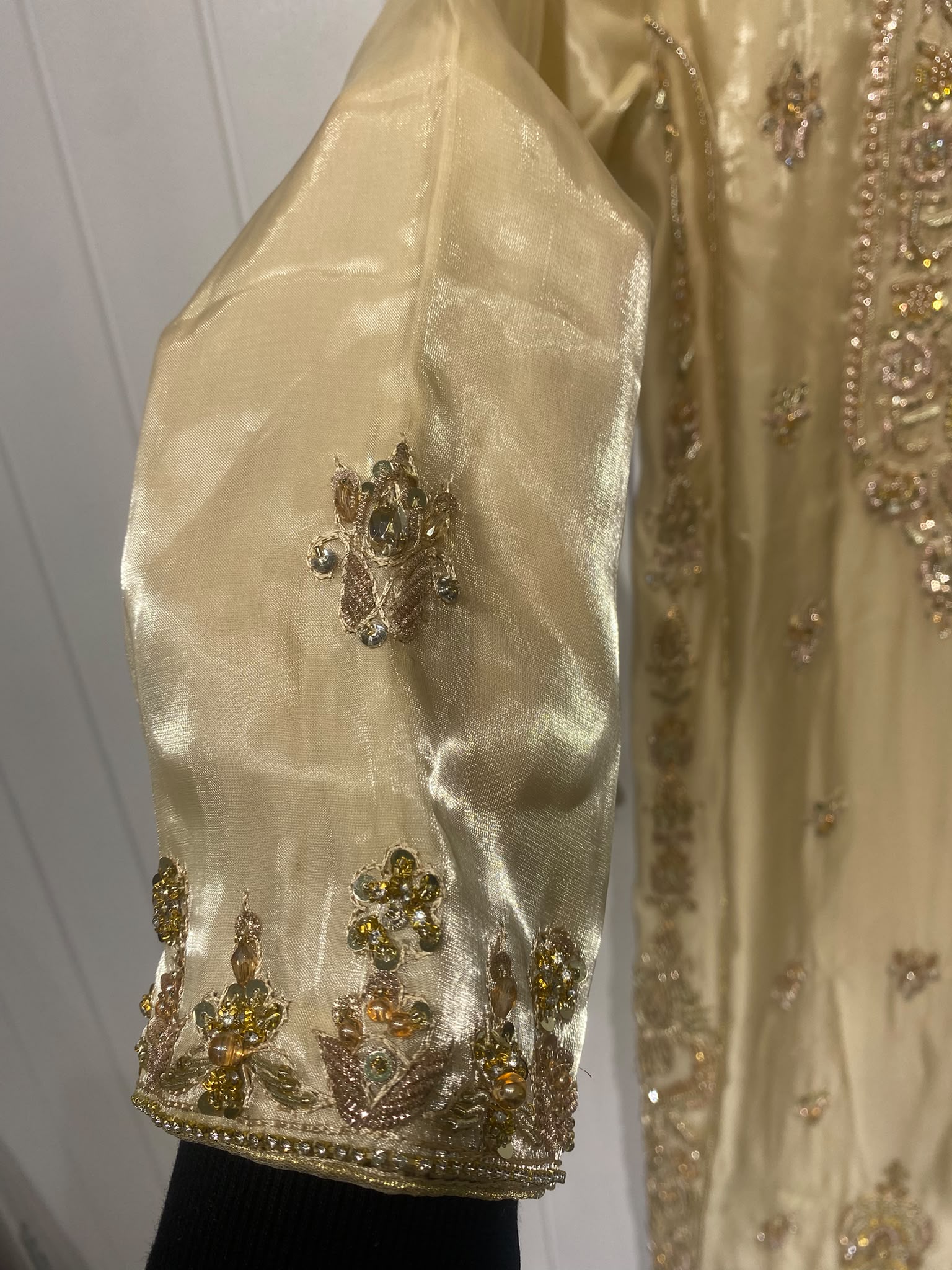 A champagne gold ensemble with an ornate embroidered neckline…