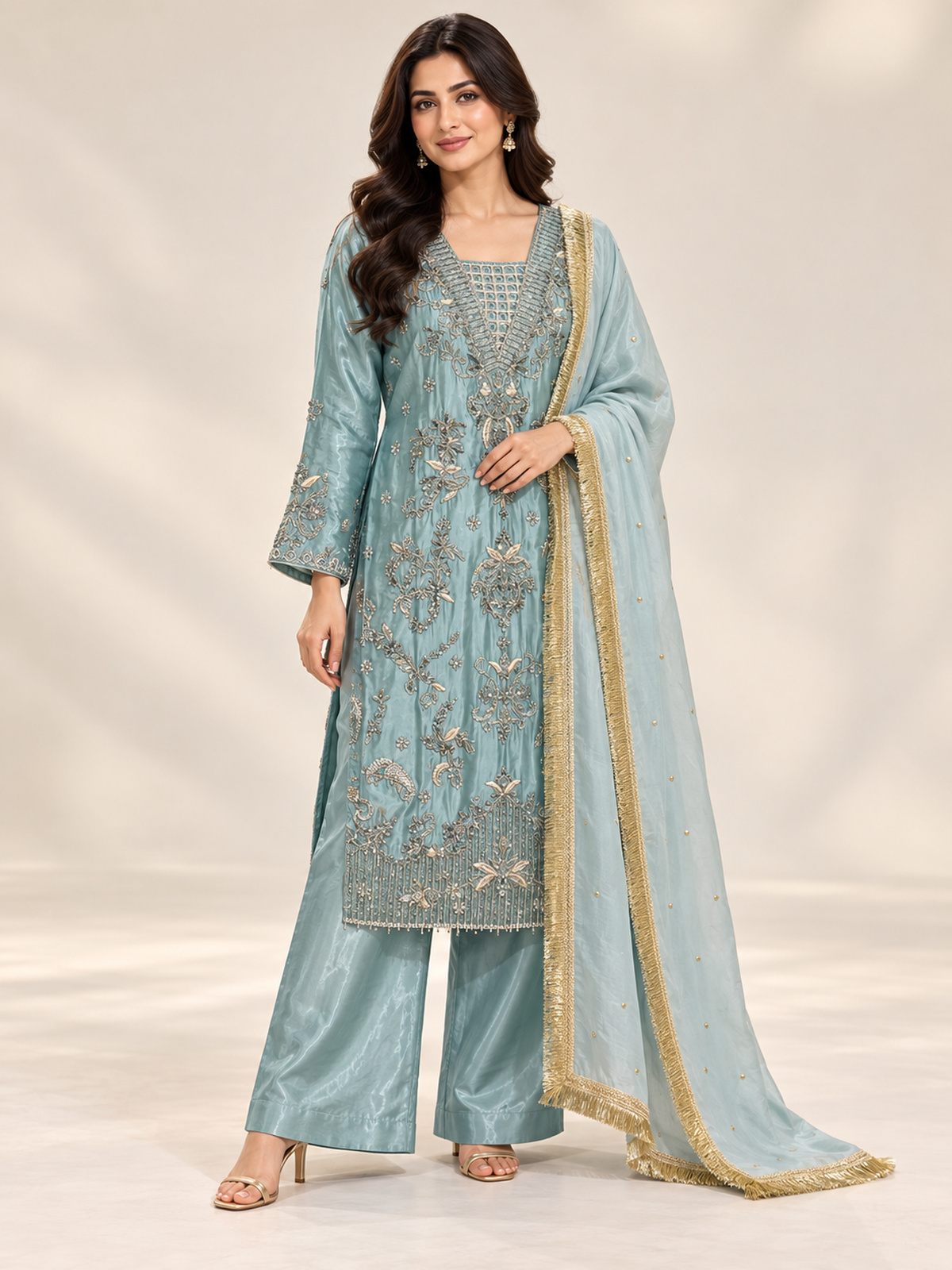 A lustrous aqua blue shirt with ornate gold-toned embroidery…