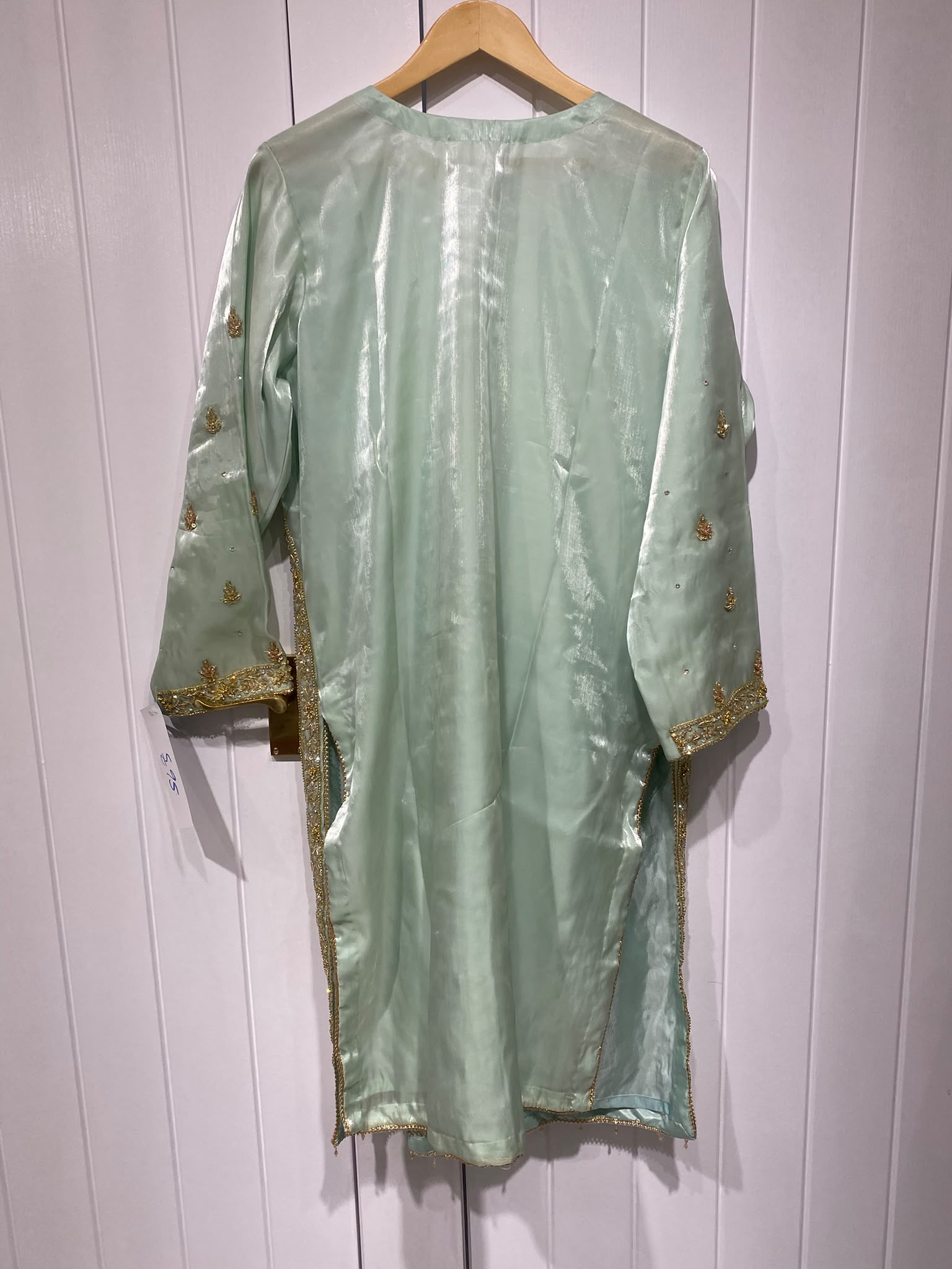 A pale mint ensemble with a decorative neckline, long embroidered…