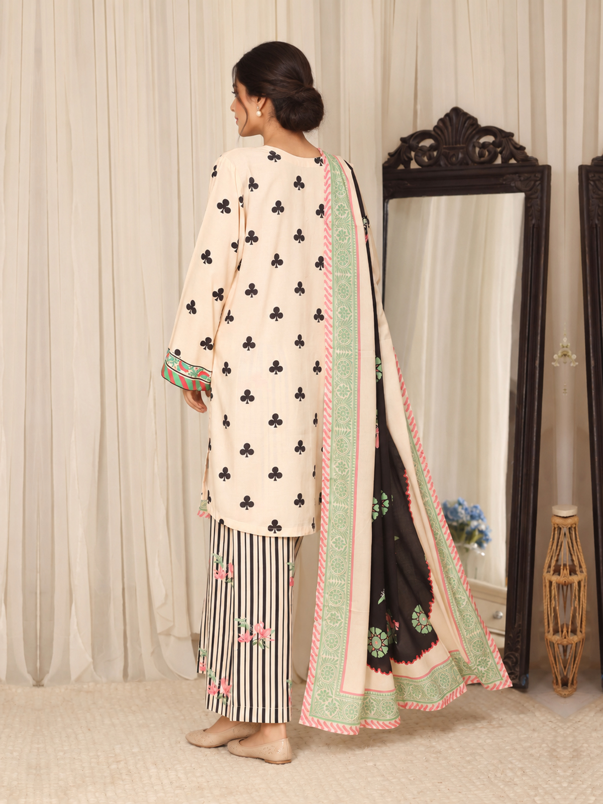 An ivory shirt patterned with black club-shaped motifs, striped…