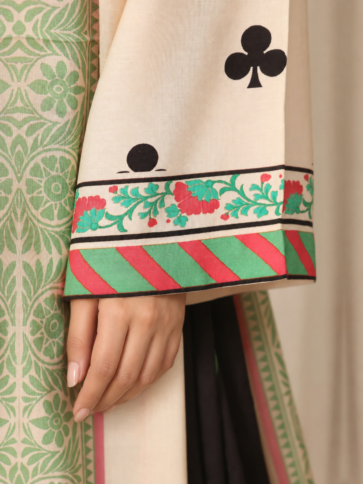 An ivory shirt patterned with black club-shaped motifs, striped…