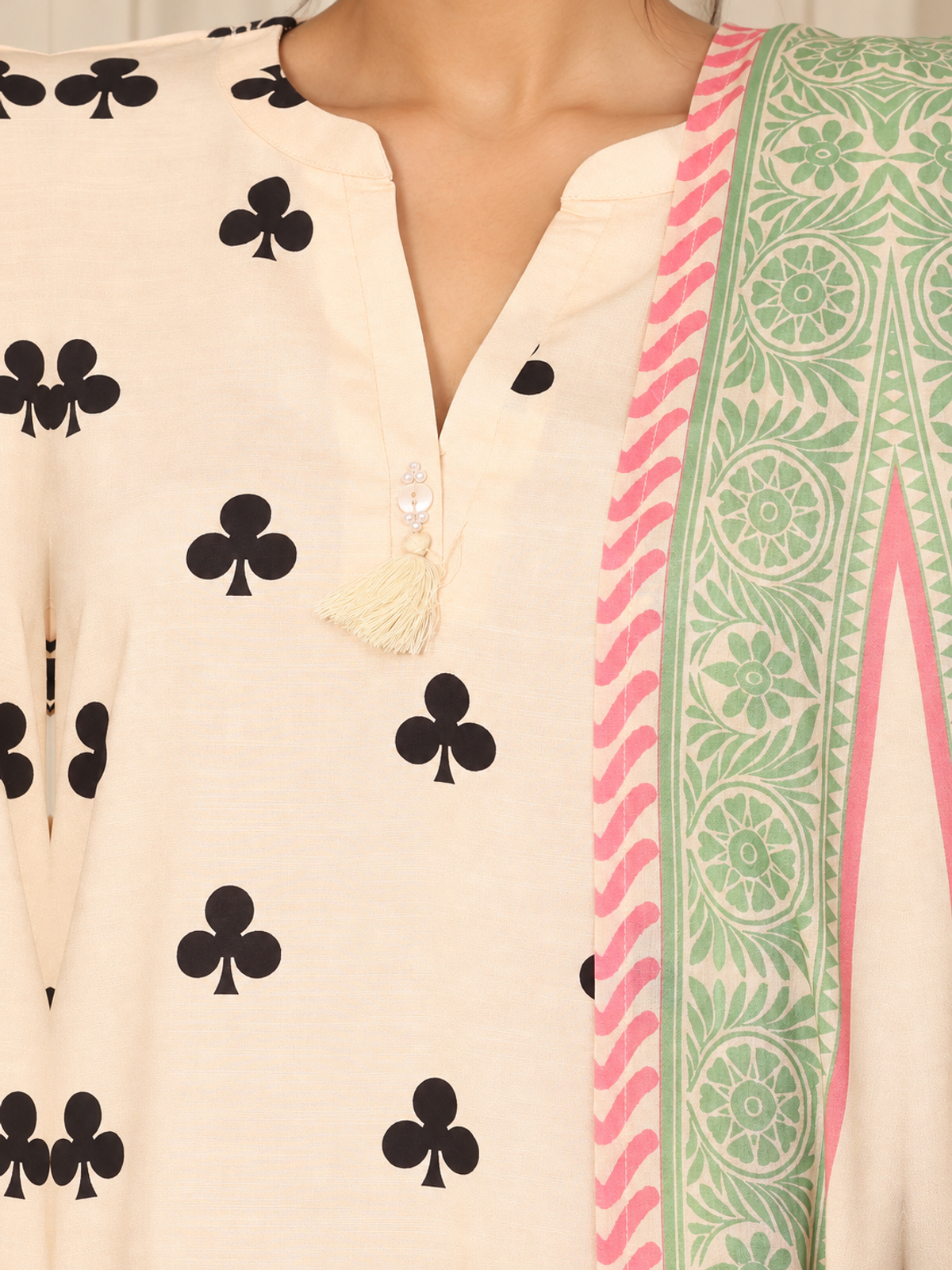 An ivory shirt patterned with black club-shaped motifs, striped…