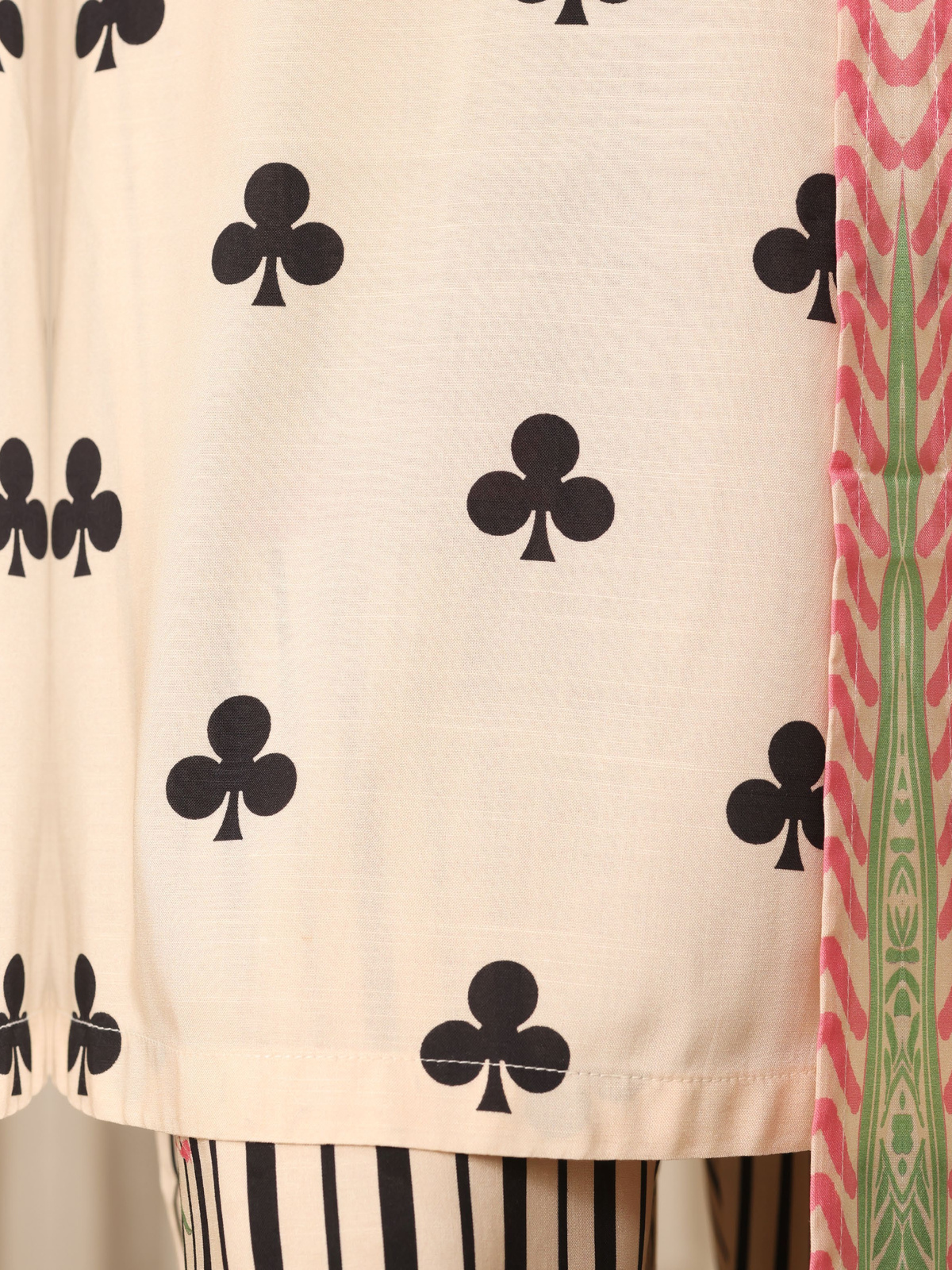 An ivory shirt patterned with black club-shaped motifs, striped…