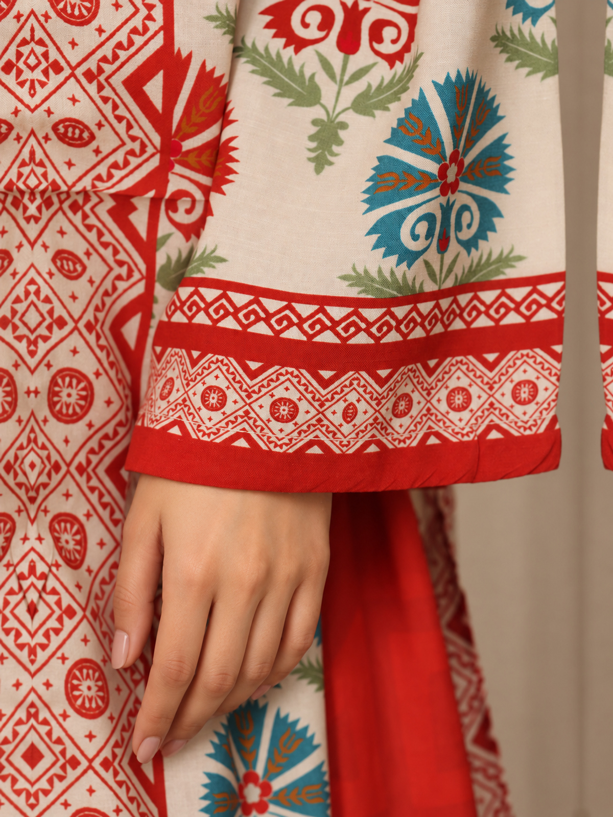 An ivory shirt with red and green ornamental motifs, red patterned…