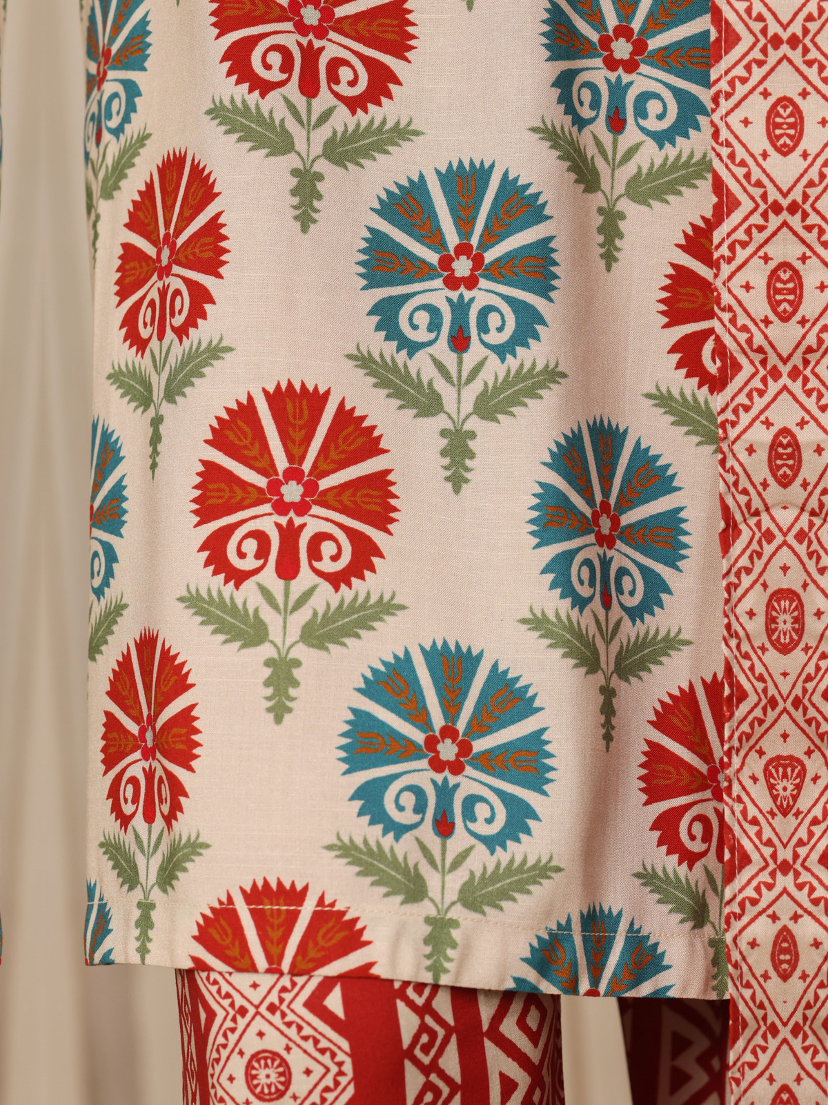 An ivory shirt with red and green ornamental motifs, red patterned…