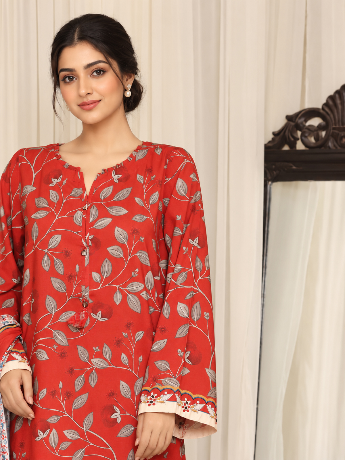 A red shirt covered with pale botanical motifs, teamed with cream…