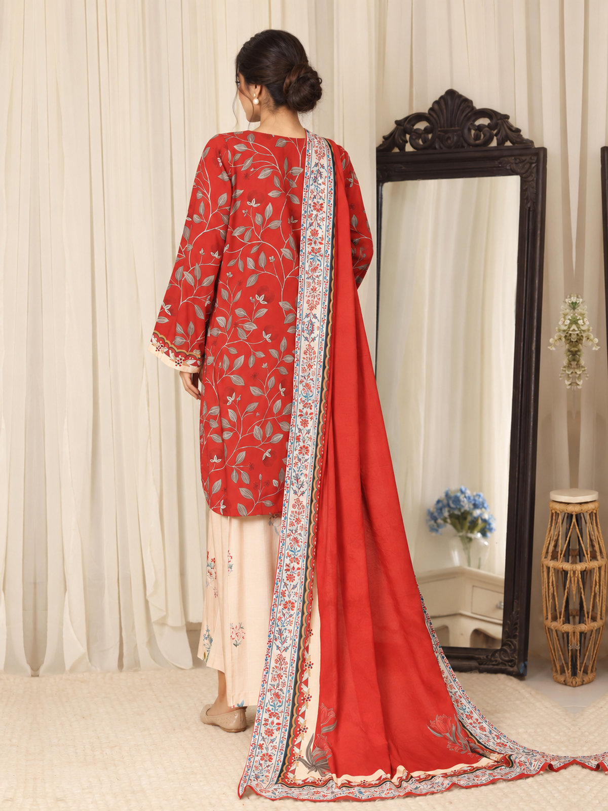 A red shirt covered with pale botanical motifs, teamed with cream…