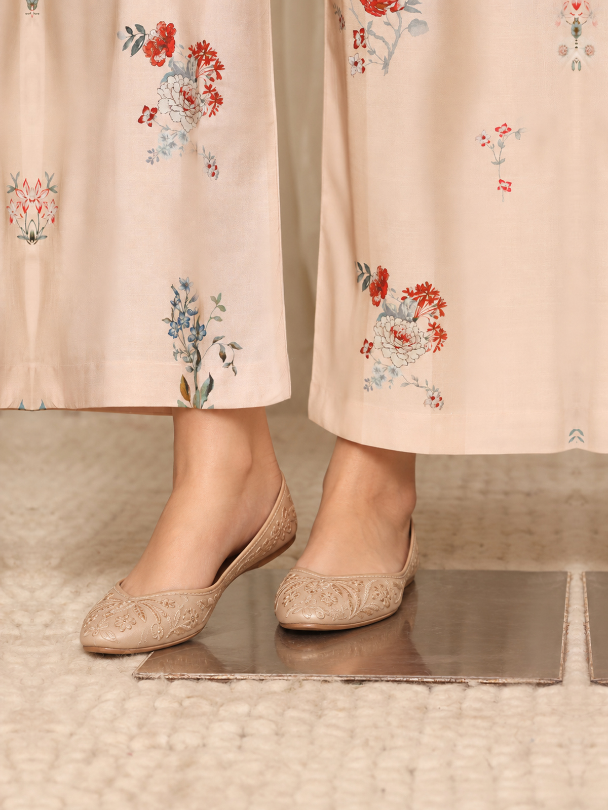 A red shirt covered with pale botanical motifs, teamed with cream…