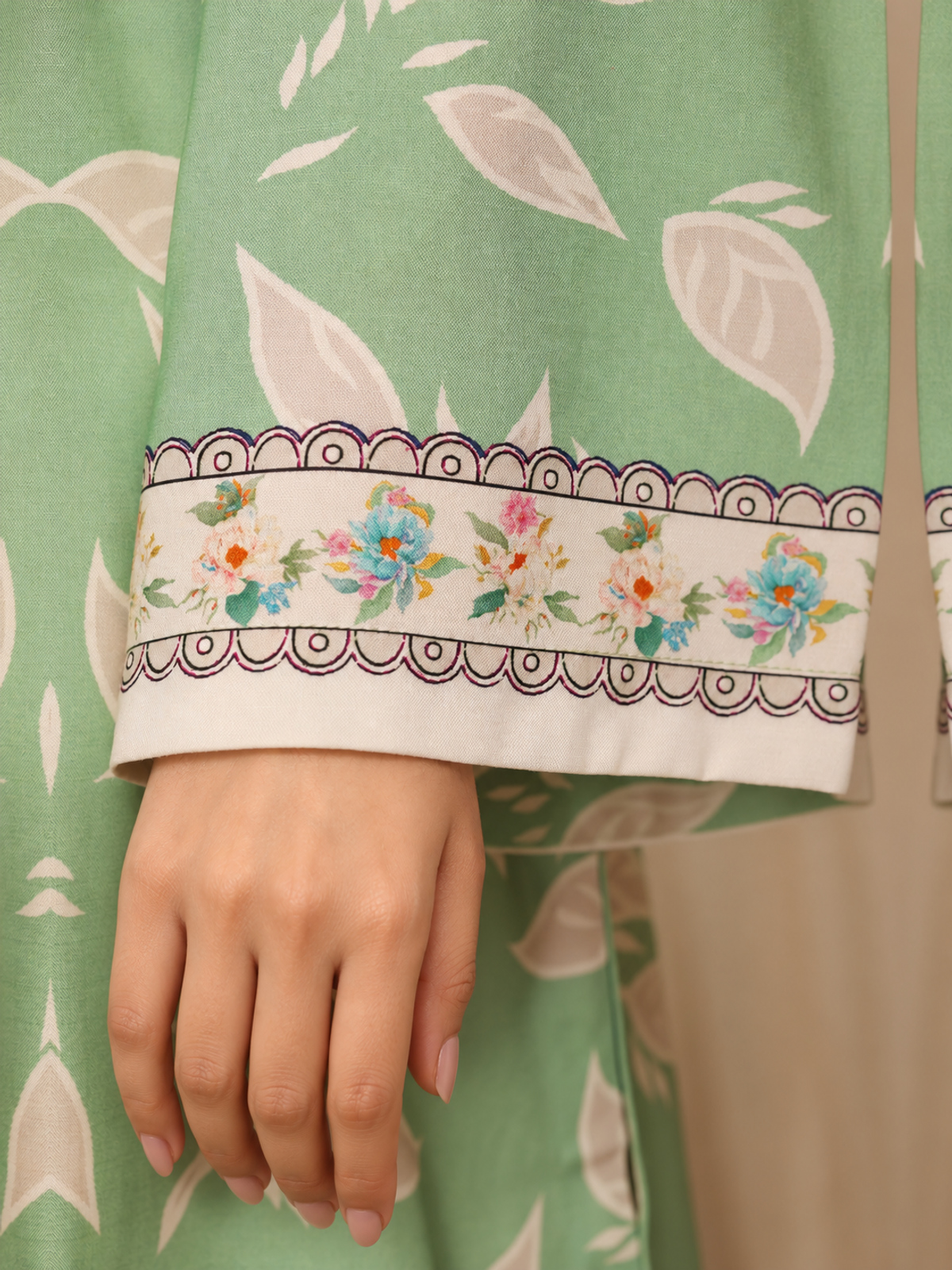A sage-green shirt with pale botanical motifs, cream floral trousers…